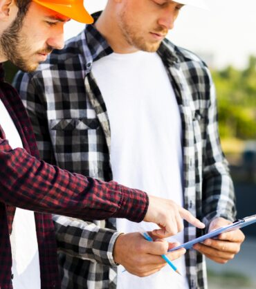 close-up-engineer-architect-looking-clipboard